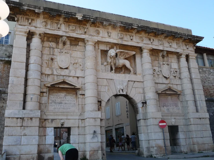 a large arch made out of stone with a person standing in front of it