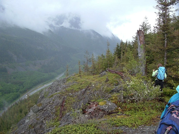 a hiker and her backpack on the top of a rocky mountain