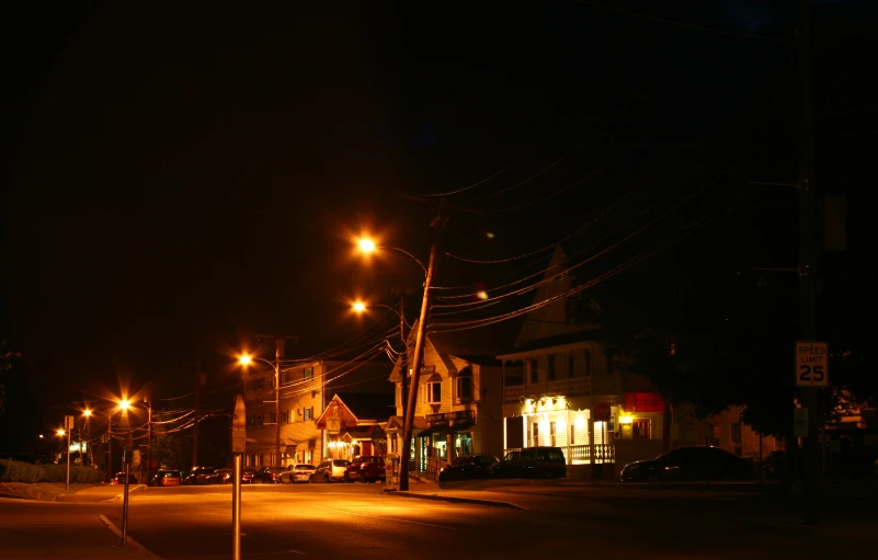 an empty city street at night with street lamps