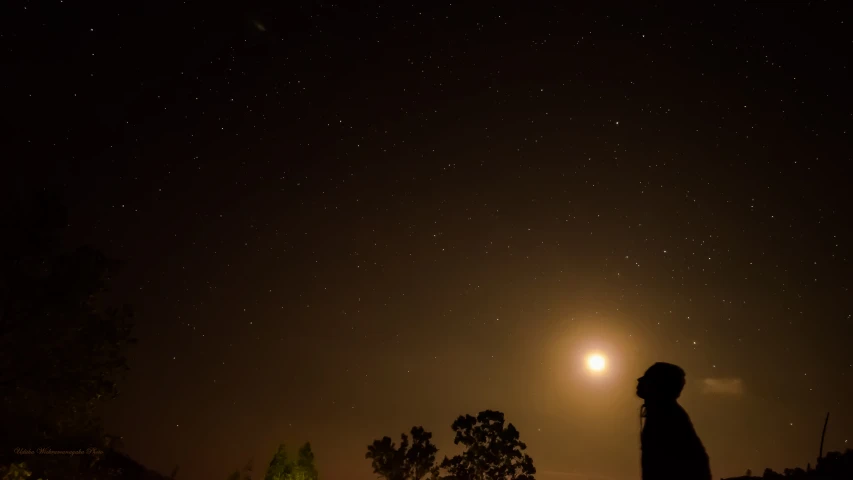 silhouetted person in the dark, night time po of stars