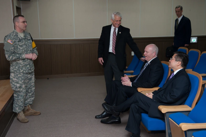 military personnel talking to soldiers in chairs