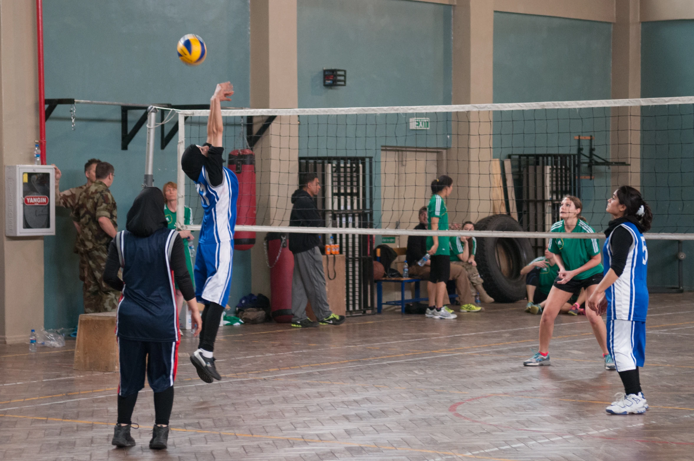 people are playing volleyball in a court while a crowd watches