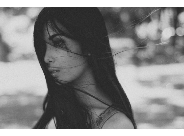 a woman with long hair standing by herself