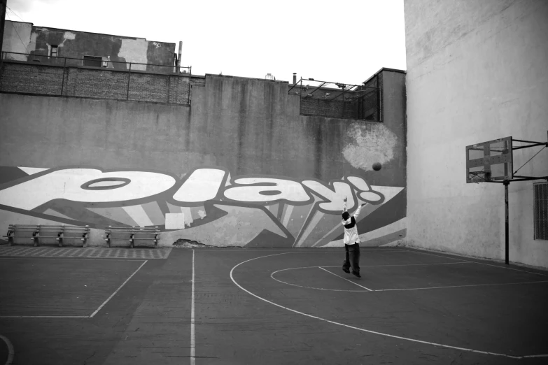 man on basketball court with street wall art