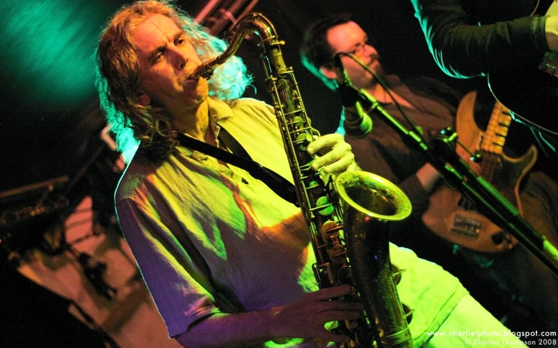 a man that is playing a saxophone on a stage