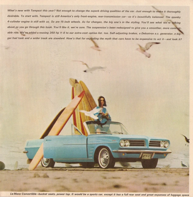 an old car in the sand with surfboards leaning out the front window