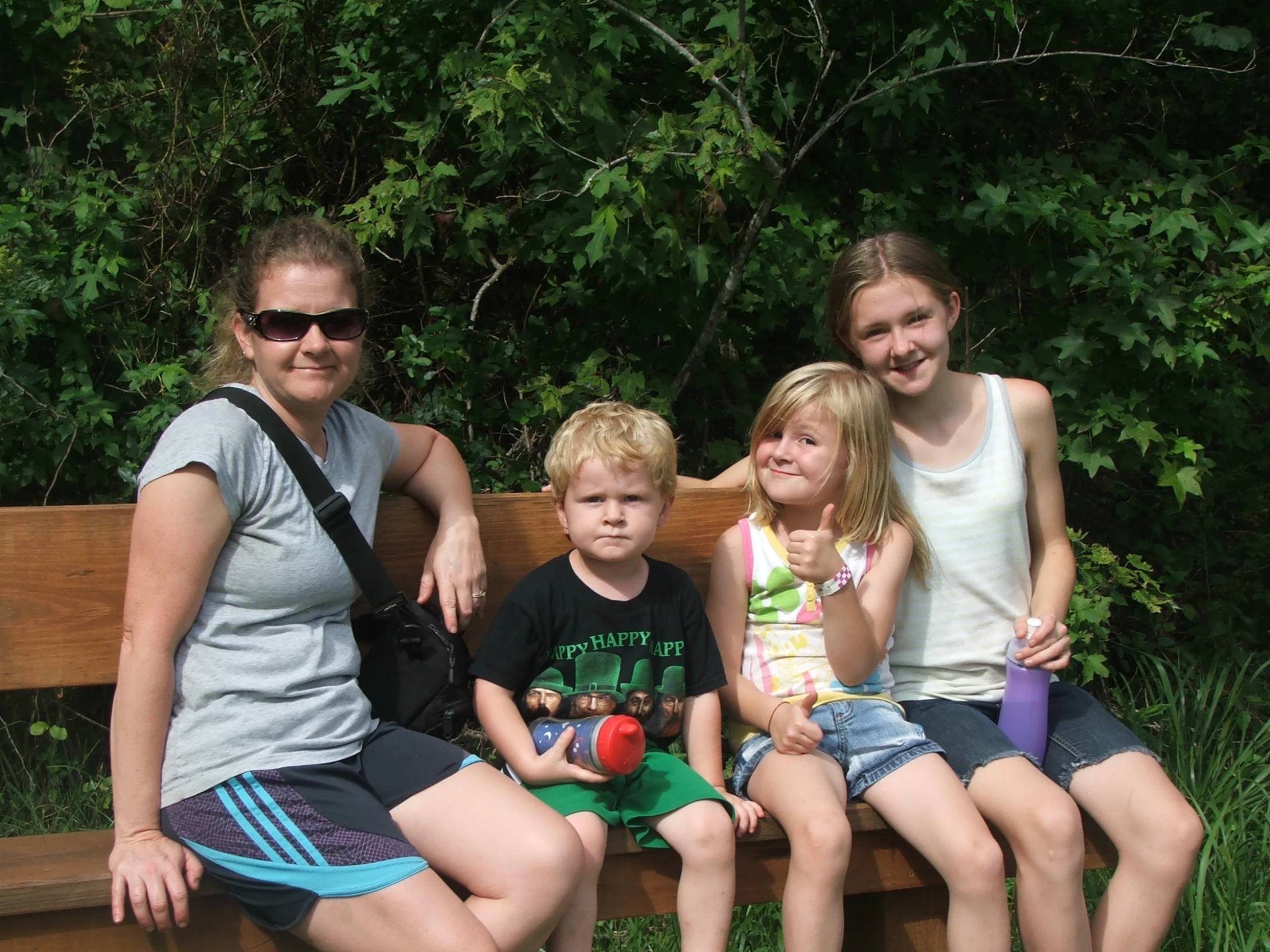 two adults and one child sitting on a bench