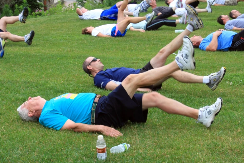 a group of people doing h ups in the grass