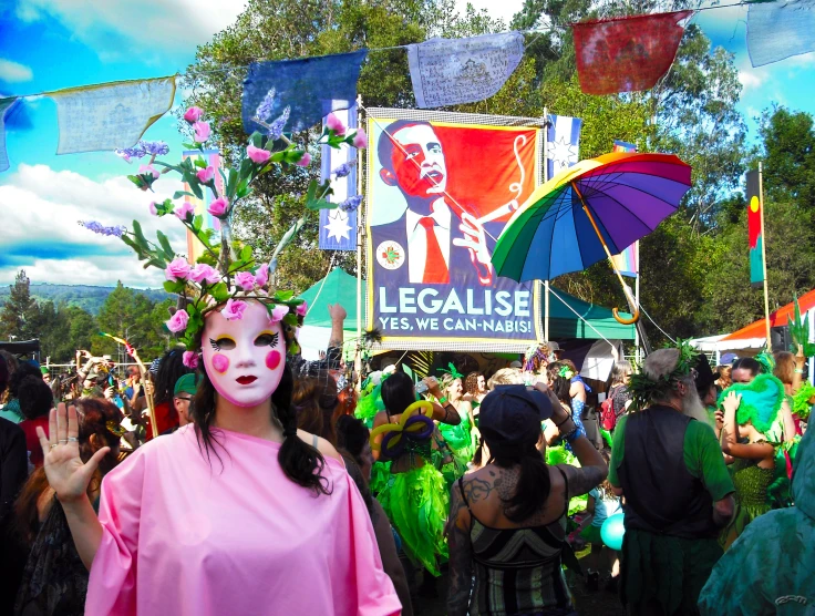 a woman with face paint standing in front of a group of people