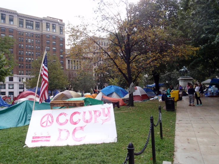 a occupy sign sits in front of an american flag