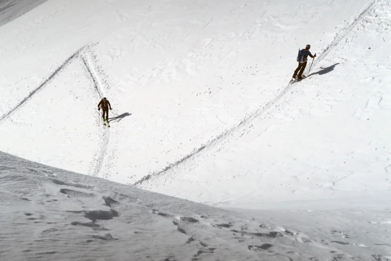 the skiers are walking up a mountain slope