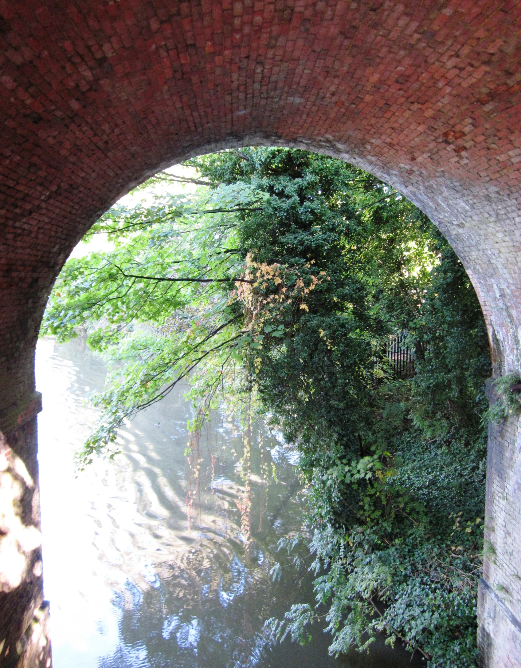 a large brick archway near a river