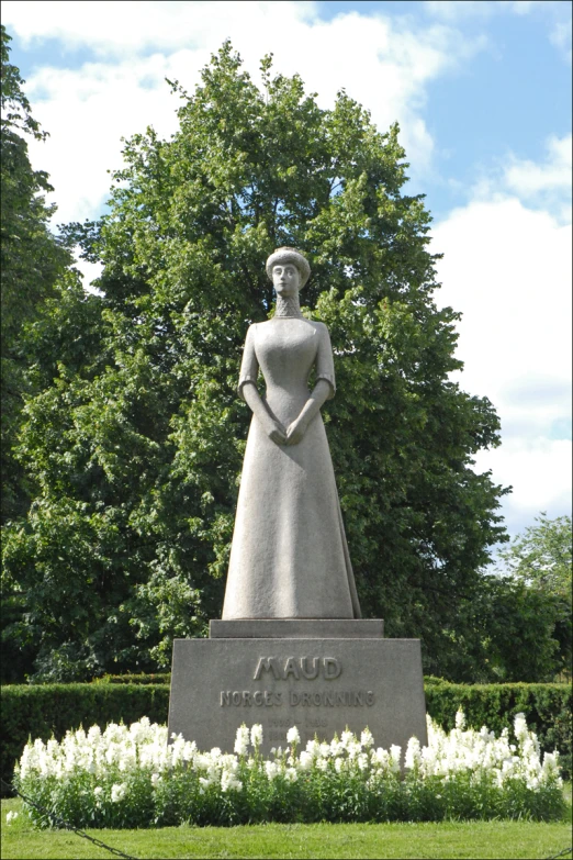 the large monument is next to some trees and white flowers