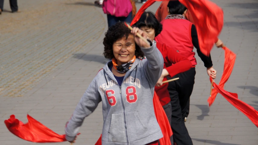 an old woman is dancing in front of many other people