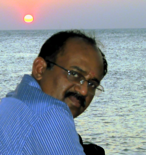 man in glasses with a sunset in the background