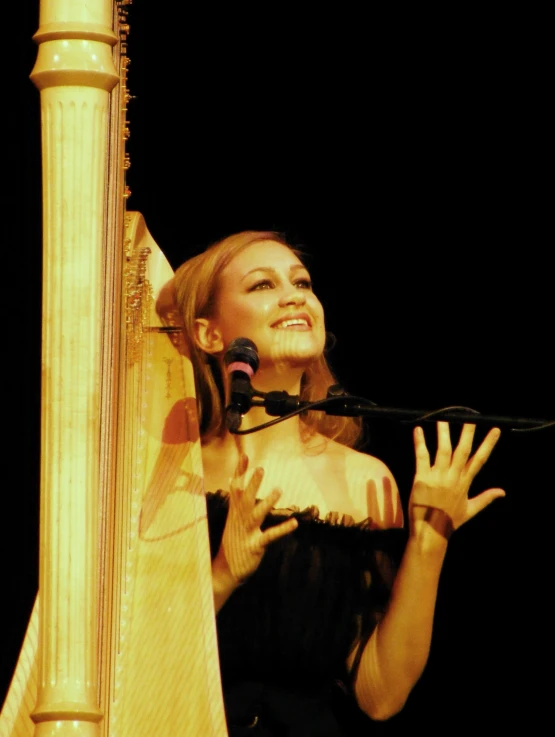 a woman holding a microphone and singing into a microphone
