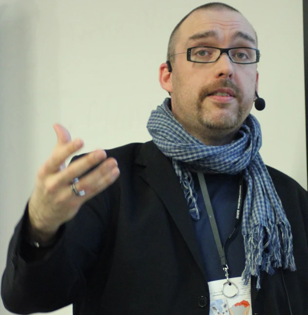 a man wearing a scarf is showing off his fingers