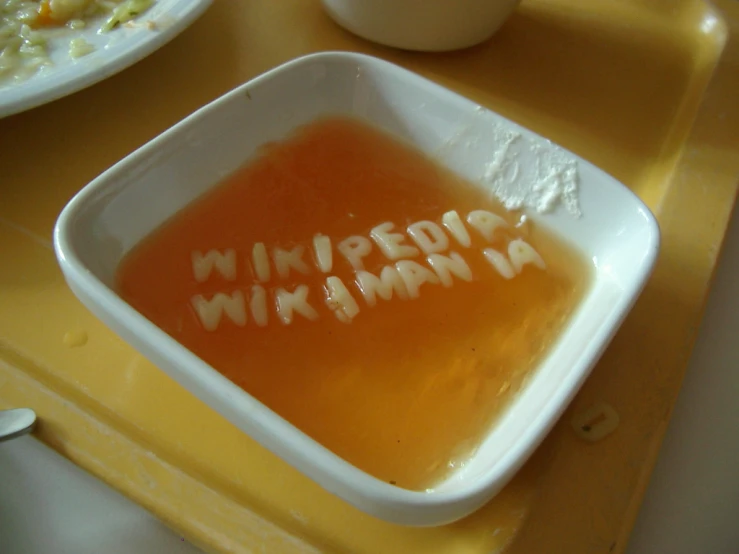 a big bowl on the tray of food with writing