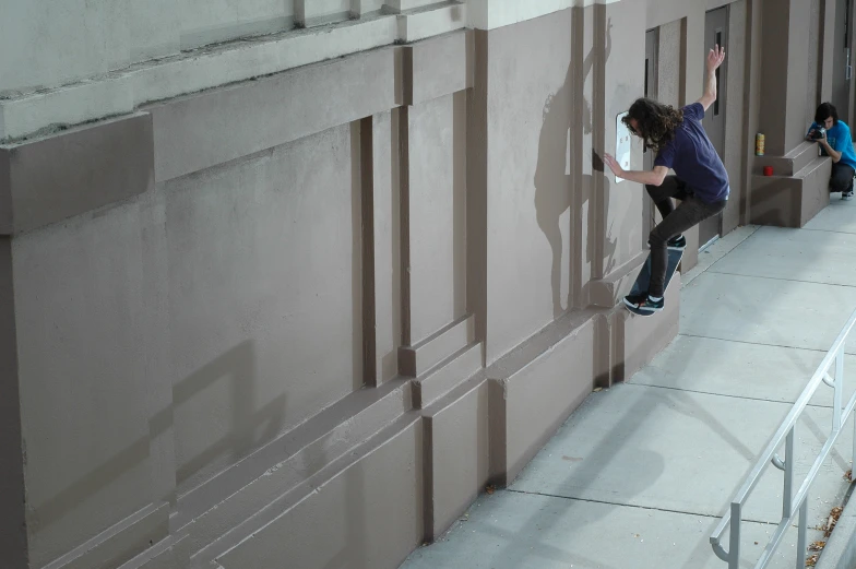 a boy skateboarding on concrete and performing a trick