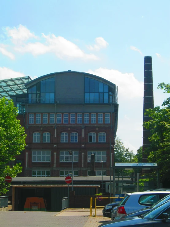 there is a brown brick building behind many cars