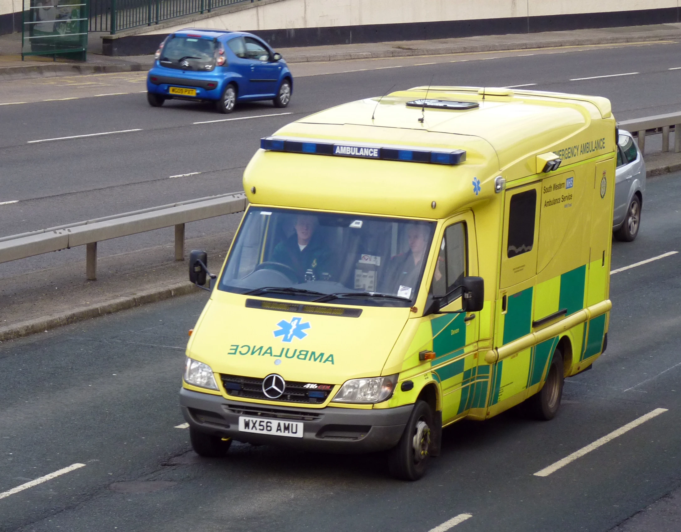 an ambulance on the road with an adult in the back