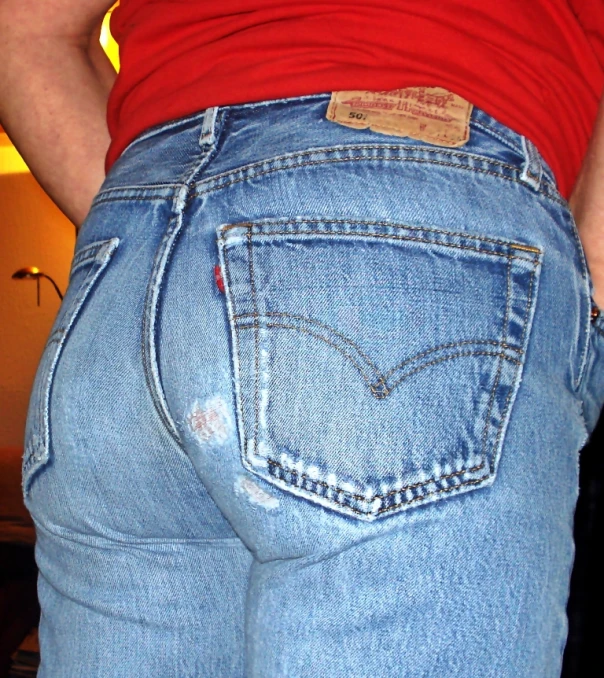 a woman wearing light blue jeans and a red top