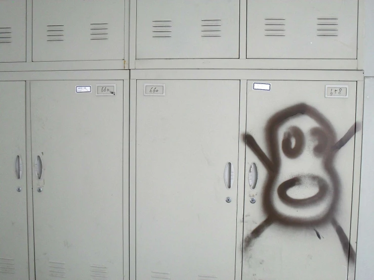 a wall with a bunch of lockers covered in graffiti