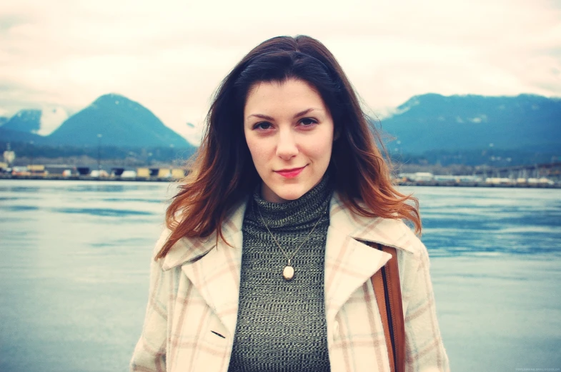 a girl with brown hair is posing for the camera