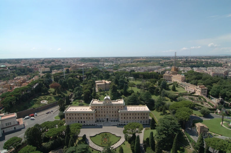 an aerial view of a large house, trees, and park