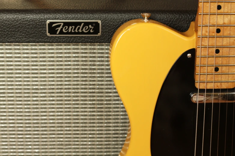 an orange fender guitar in front of a guitar amp