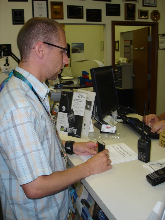 a man at a desk and a person behind a laptop