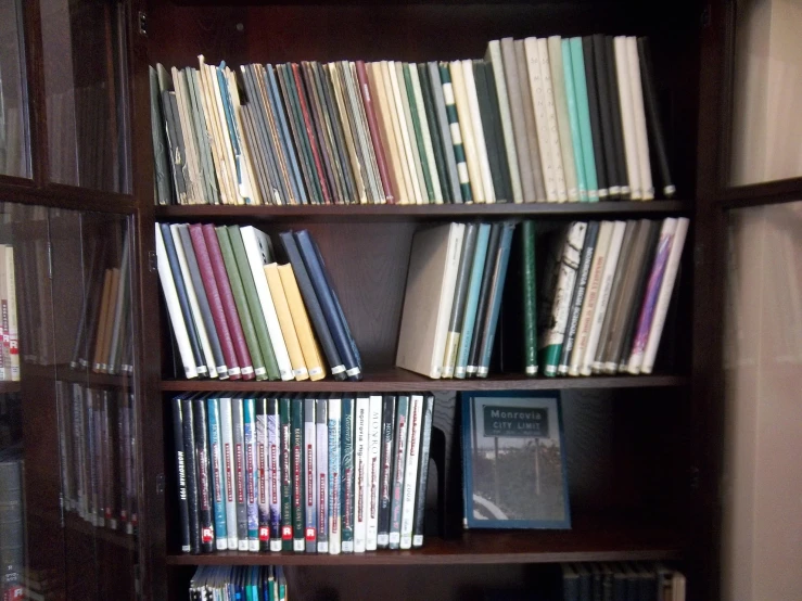 a wooden bookshelf holding many books and other items