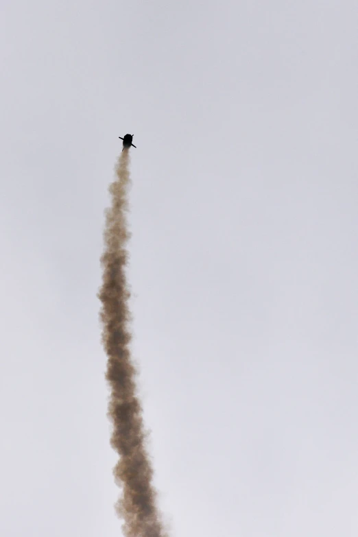 a plane flying low in the sky doing a trail