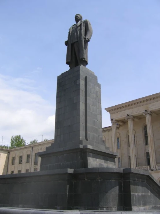 a monument with a statue on top and columns below it