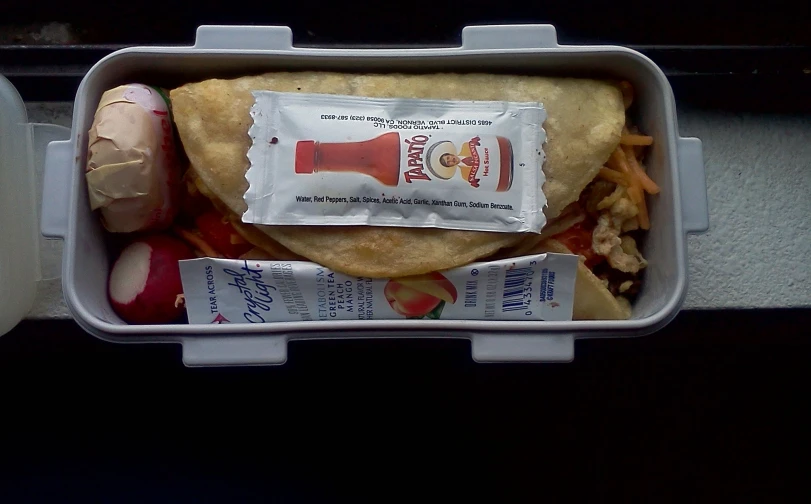 food in container sitting on shelf next to napkins