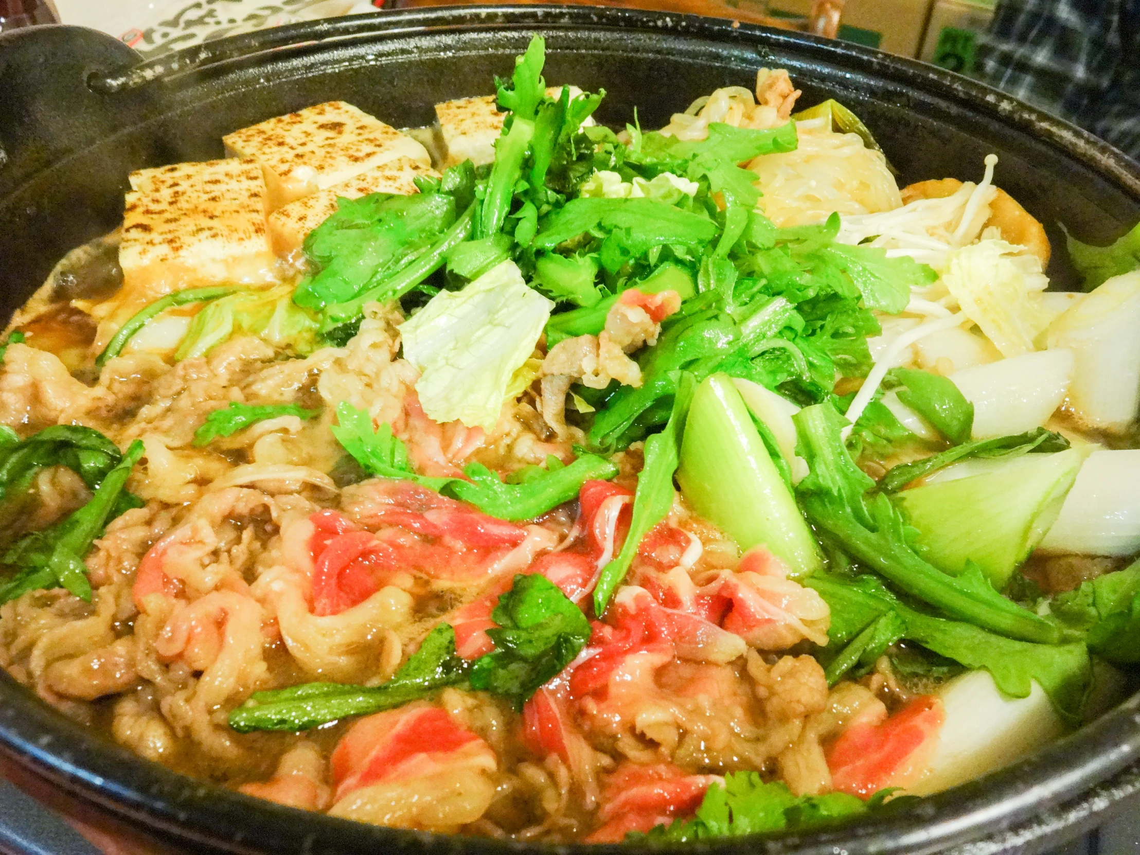 a bowl of food containing green onions and meat