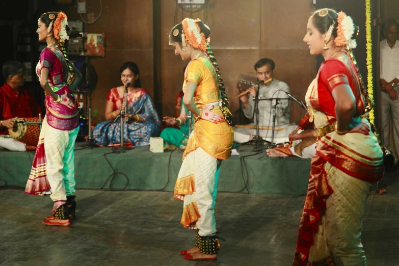 women performing a dance in colorful clothing and holding garlands