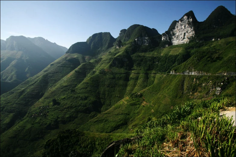 a view of some mountains in the distance with grass on the side