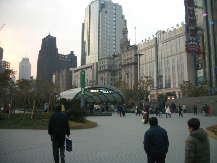 several people in a city square with tall buildings