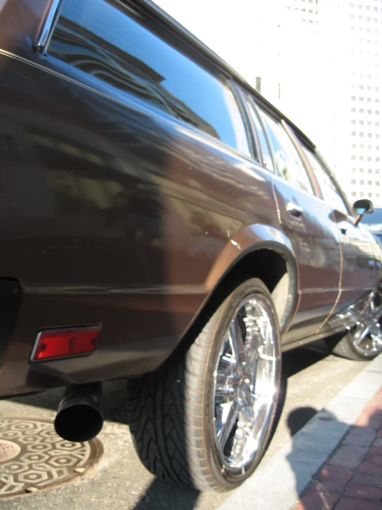 a parked brown car next to a building