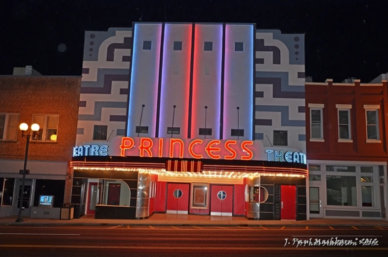 the entrance to a el at night with lit sign