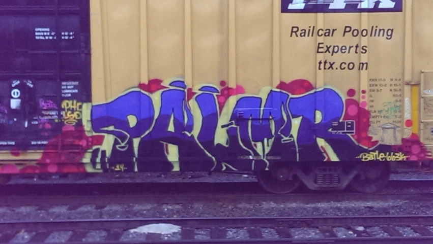 the graffiti is spray painted on the back of the cargo car
