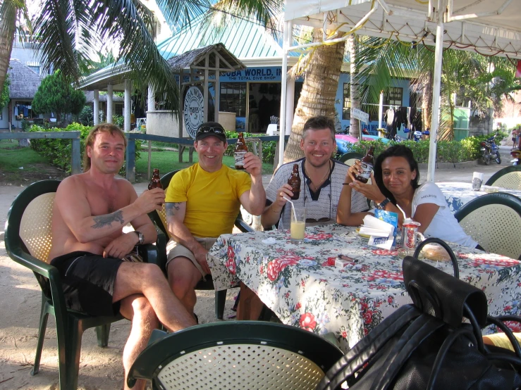 three people sitting at a table with drinks in their hands