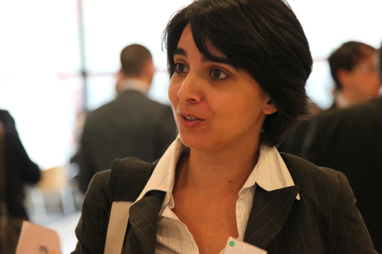 woman sitting in an office and wearing an open collar jacket