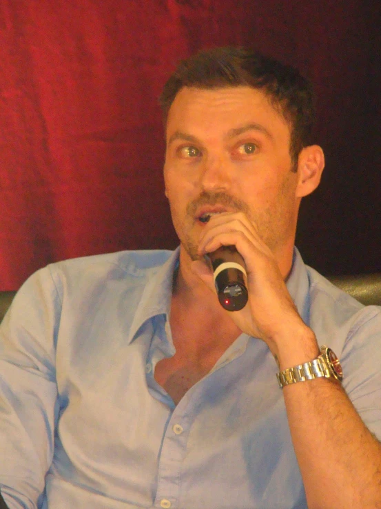 a man in a blue shirt holding a microphone