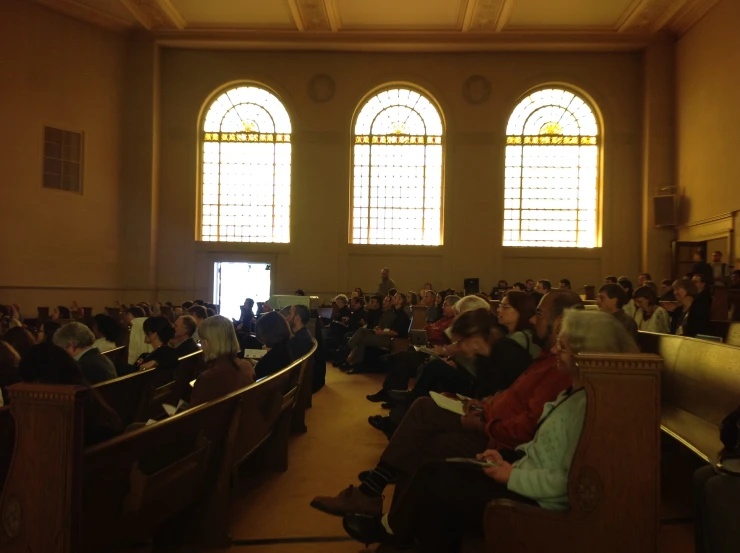 a crowd is in a large room during a seminar