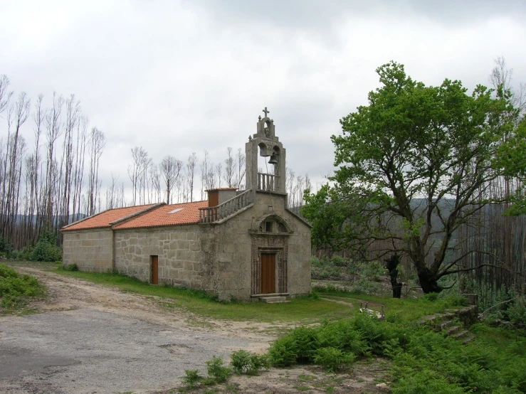 a very old stone church in the middle of a road