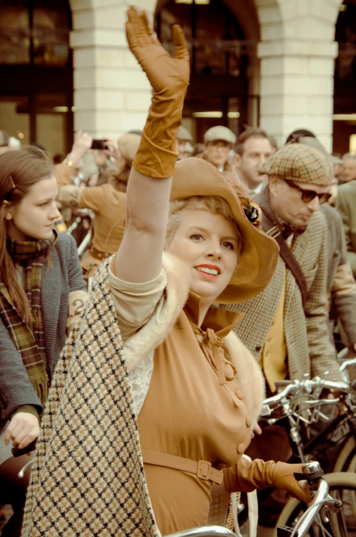 an old fashion woman wearing hat and gloves waves