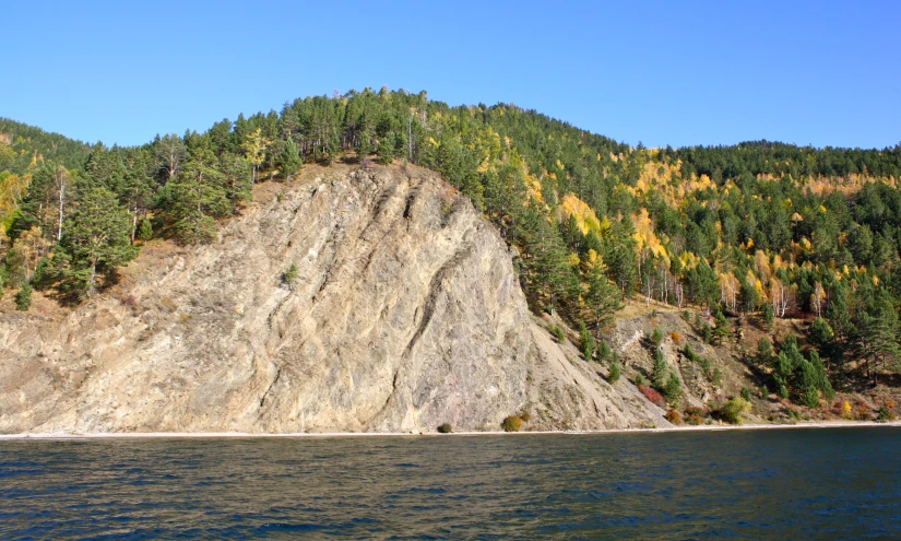 the side of a mountain with trees in the background