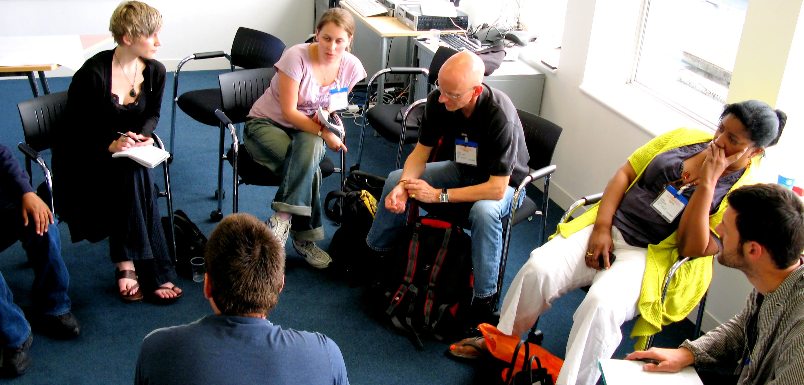 people sit in chairs in an office as one person takes a po